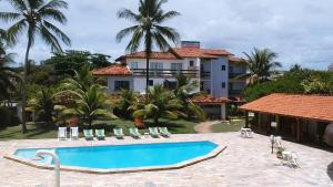 a swimming pool in front of a house at Hotel La Dolce Vita in Ilhéus