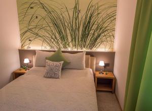 a bedroom with a bed with a plant on the wall at Ferienwohnungen Bergsonne und Gipfelsonne in Bad Reichenhall