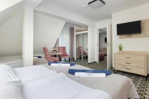 a hotel room with two beds and a television at Villa Solaris in Pobierowo