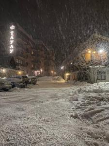 a city street covered in snow at night at Taulu in Dombay