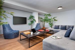 a living room with a couch and a tv at Filopappou Hill Suites by Athens Stay in Athens