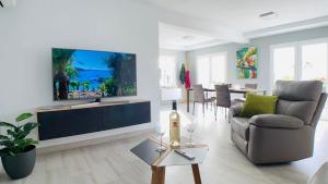 a living room with a large flat screen tv on a wall at Casa Solaris at Anfi Beach with Private Terrace, Pool & Netflix in Arguineguín