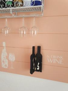 dos botellas de vino y copas de vino colgando en una pared en Sweet&Wine Apt with terrace by Flamingo House en Arrecife