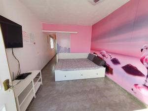 un dormitorio con paredes rosas y una cama con flamencos. en Sweet&Wine Apt with terrace by Flamingo House en Arrecife