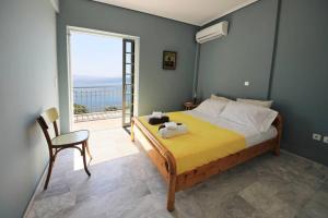 a bedroom with a bed with a view of the ocean at EVILION SEA SIDE MAISONETTE in Ambelón