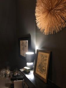 um quarto com uma mesa com um candeeiro e uma fotografia em La mosane em Profondeville
