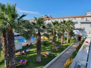 a view of a resort with palm trees and chairs at Centro Vacanze Domus M.G. in San Benedetto del Tronto