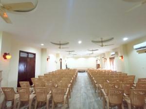 an empty room with chairs and tables and ceilings at SGS Lodgings International in Nāgercoil