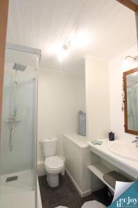 Baño blanco con aseo y lavamanos en Villa Denise Petit Gîte, en Barneville-Carteret
