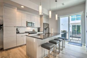 a kitchen with a bar with stools in it at Trendy Denver Townhome - Walk to Mile High Stadium in Denver