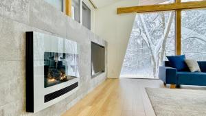 白馬的住宿－Sanzan Chalet by Hakuba White Fox Company，客厅设有壁炉和蓝色沙发。