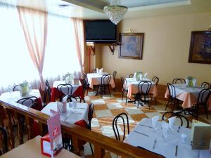 a dining room with tables and chairs and a tv at Hotel Can-Vic in Guadalajara