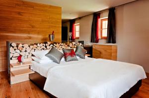 um quarto com uma grande cama branca e paredes de madeira em Penzion Repnik em Kamnik