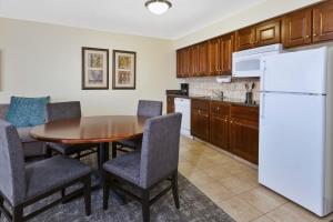 a kitchen with a table and chairs and a refrigerator at Staybridge Suites Lansing-Okemos, an IHG Hotel in Okemos