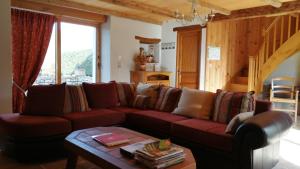 a living room with a red couch and a table at Le Mas de La Pommeraie in Saint-Géry