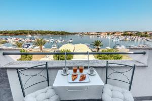 a table with food on a balcony with a marina at Penthouse Zola with private parking in Medulin