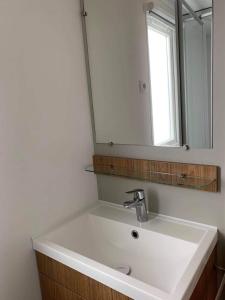 La salle de bains est pourvue d'un lavabo blanc et d'un miroir. dans l'établissement VAM Mobil Home Mar Estang, à Canet