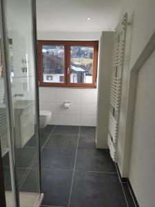 a bathroom with a toilet and a sink and a window at Ferienwohnung Stillleben in Ofterschwang