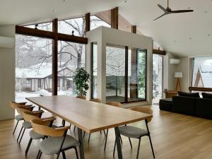 a dining room with a wooden table and chairs at Ahiru Chalet by Hakuba White Fox Company in Hakuba