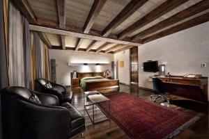 a bedroom with a bed and a desk and chairs at Hotel Stary in Krakow