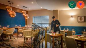 um homem de pé numa sala de jantar com mesas em Clayton Hotel & Leisure Club Sligo em Sligo