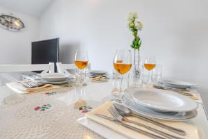 una tavola con bicchieri di vino, piatti e argenteria di Penthouse Zola with private parking a Medulin Altre 7 foto