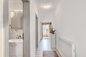 un bagno bianco con lavandino e corridoio di Penthouse Zola with private parking a Medulin