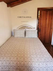 a bed in a room with a sign on the wall at CHR Talasnal_Casa da Pedra in Lousã