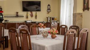 una sala da pranzo con tavolo e fiori di Pensiunea Ana a Cavnic