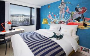 a bedroom with a bed and a painting on the wall at 25hours Hotel beim MuseumsQuartier in Vienna