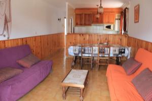 un soggiorno con divano viola e una cucina di Riells Blau a L'Escala
