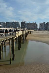 a pier on the beach with people sitting on it at Sfeervol appartement te Blankenberge in Blankenberge +15 photos