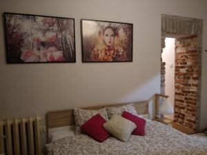 - une chambre avec 3 photos sur le mur et un lit dans l'établissement Sztukmistrz Magician Art Rooms, à Lublin