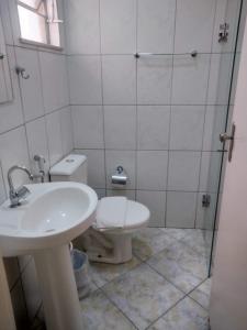 a bathroom with a toilet and a sink at Lelis Hotel in Itapira