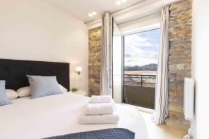 1 dormitorio con cama grande y ventana grande en The Rentals Collection - Monpas, en San Sebastián