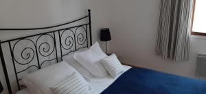 een bed met witte lakens en kussens in een slaapkamer bij Gîte le tréportais in Le Tréport