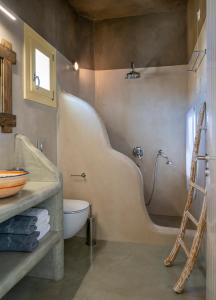 uma casa de banho com um chuveiro, um WC e um lavatório. em Pangaia Seaside Ηotel Adults Only em Koufonisia
