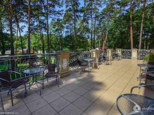 an outdoor patio with tables and chairs and trees at Villa Kama in Skorzęcin +9 photos