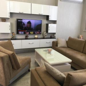 a living room with a couch and a tv at Сдается уютная двухкомнатная квартира с джакузи в Батуми in Batumi
