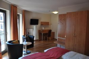 Habitación de hotel con cama, mesa y sillas en Hotel Restaurant Zum Schwan, en Mettlach
