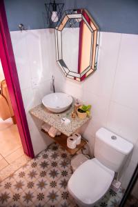 ein Badezimmer mit einem weißen WC und einem Waschbecken in der Unterkunft Aconchego de Tiradentes in Tiradentes