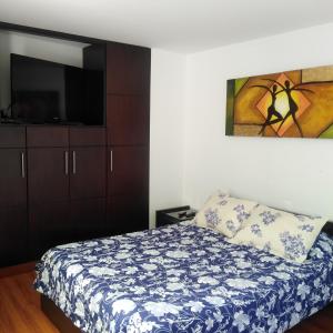 a bedroom with a bed and a flat screen tv at Posada Ventura in Duitama