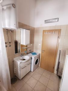 La salle de bains est pourvue d'un lave-linge et d'un lavabo. dans l'établissement Apartman Zora, à Podstrana