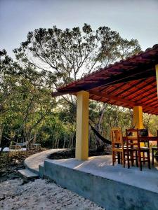 un patio con mesa y sillas bajo un pabellón en Espaço Terra Dourada, Ibicoara, Chap Diamantina, en Ibicoara