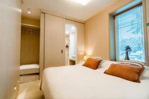 - une chambre avec un grand lit blanc et une fenêtre dans l'établissement Mere 38 Apartments, à Võsu