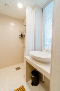 uma casa de banho branca com um lavatório e um chuveiro em Mere 38 Apartments em Võsu