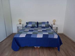 a blue and white bed in a room with two night stands at Departamento a cuadras del hospital Italiano in Buenos Aires