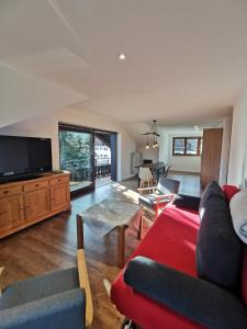 a living room with a couch and a flat screen tv at Ferienwohnung Stillleben in Ofterschwang