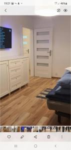 Pokój z łóżkiem i kuchnią z drewnianą podłogą w obiekcie Apartament Łąkowa w Polanicy Zdroju
