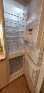 an empty refrigerator with its door open in a kitchen at Apartament Łąkowa in Polanica-Zdrój